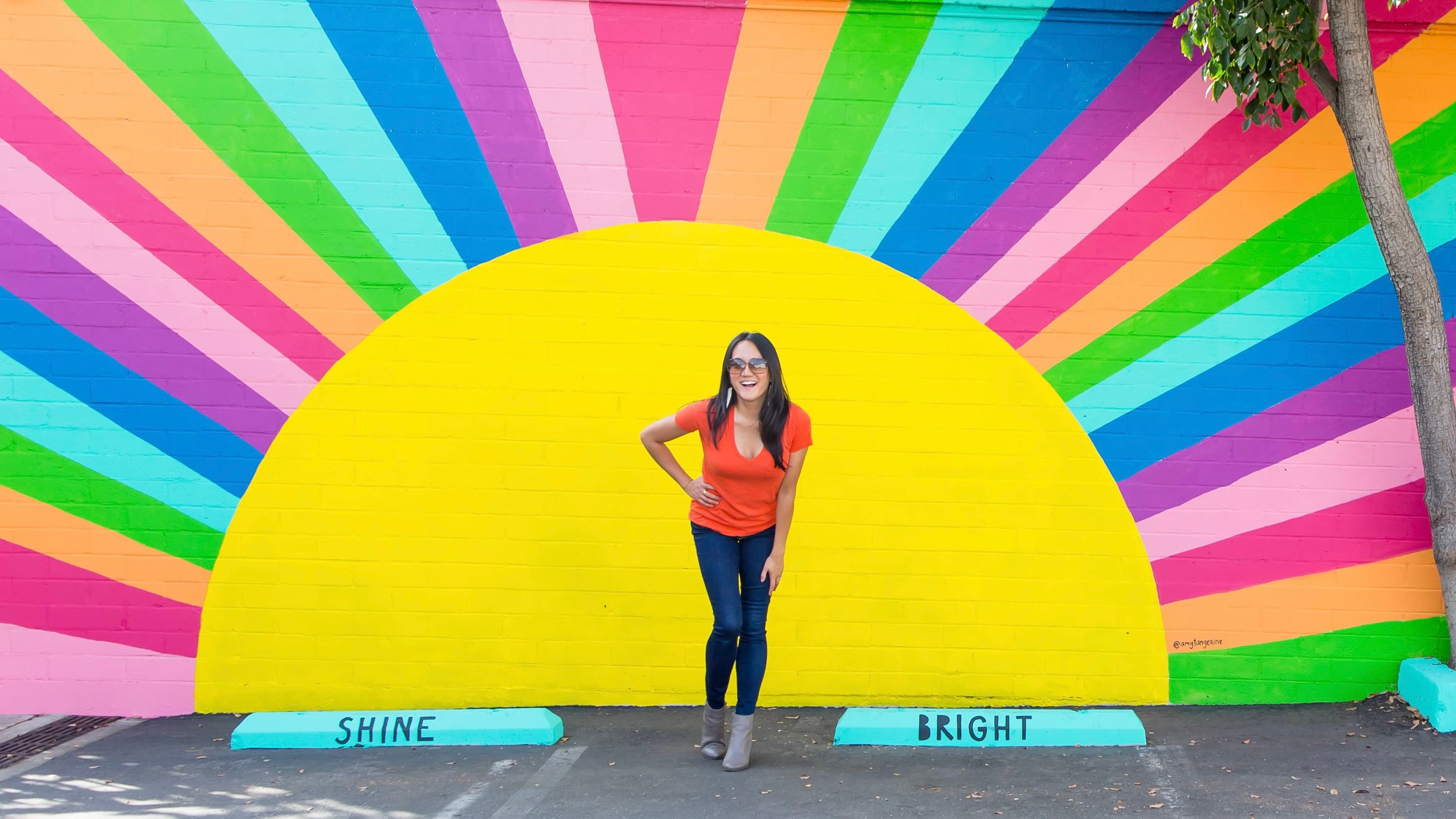Amy Tangerine in front of the Shine Bright mural