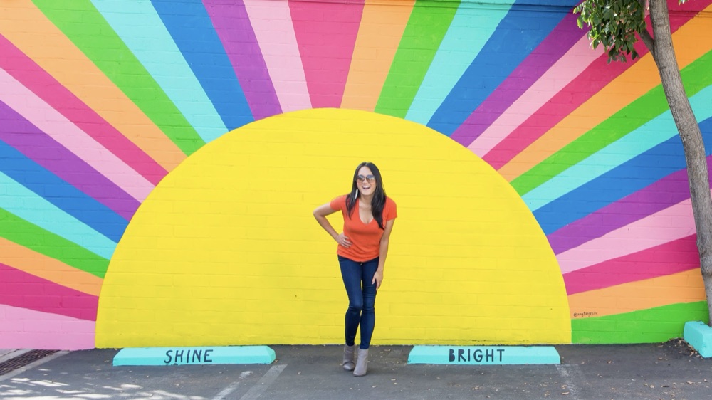 Amy in front of the Shine Bright mural